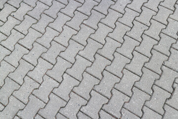 Gray curly paving slabs. Pedestrian sidewalk neatly paved with tiles.