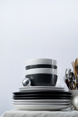 Set of black and white tableware with plates, cutlery and glasses with holiday decorations on dining table, copy space