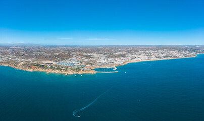 Fototapeta premium Panoramic view of Albufeira city. Perspective from above. Situated in South of Portugal is a famous travel destination. Beautiful Portuguese landscape with high rocky shore and luxury houses on top. 