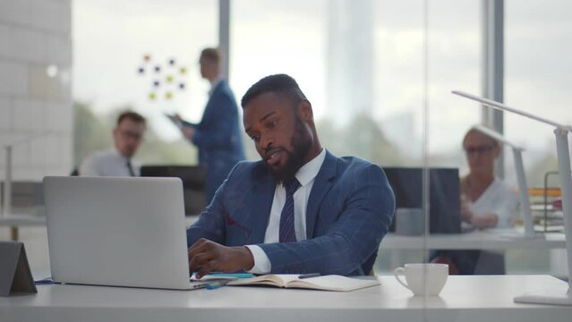 Upset man reading bad news on laptop computer at coworking space. 