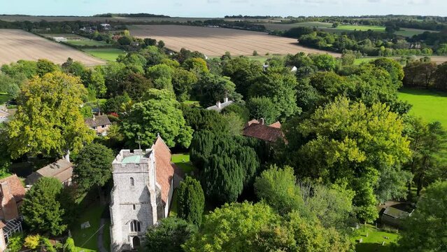 Pan down drone shot to reveal a picturesque village church in Kingston Kent