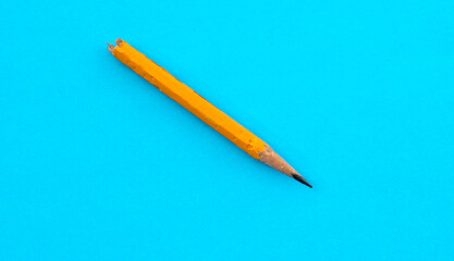 Broken pencil on blue background