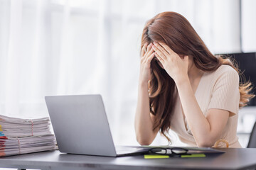 Asian businesswoman are stressed while working on laptop, Tired asian businesswoman with headache at office, feeling sick at work copy space in workplace an home office.
