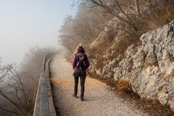 Woman walking alone on rural misty path