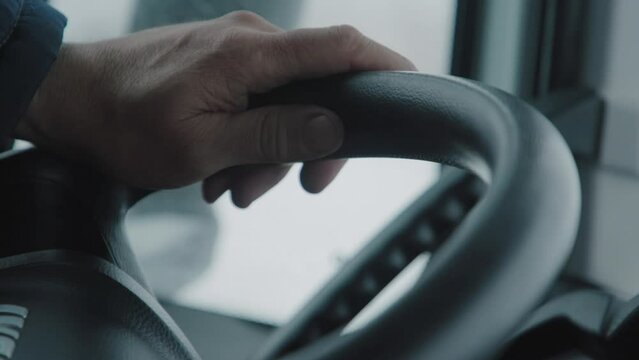 Close-up of the trucker's hand on the steering wheel. Winter road. A long drive. 4K