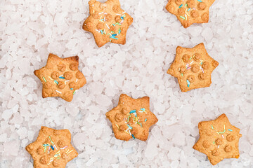 Top view of star shaped Christmas cookies on background of decorative ice pieces.