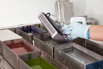 Scientist staining microscope slides for cytology studies in the laboratory.