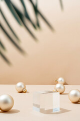 A minimalistic scene of glass podium with christmas pine tree and balls on beige background