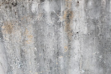 A weathered concrete wall with cracks and peeling paint, showing signs of age and decay.