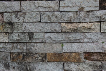 A weathered concrete wall with cracks and peeling paint, showing signs of age and decay.