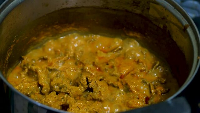 Red curry boiling on a pot with eggpalnt and herb. Making of red curry with chicken, Thai food, Pa neang.