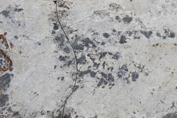 A weathered concrete wall with cracks and peeling paint, showing signs of age and decay.