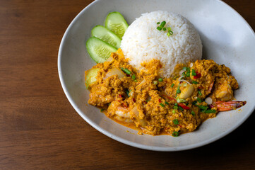 Top view of omelet in a plate on wooden table with copy space, Thai omelet style, Fried egg, Fast food, Copy space.