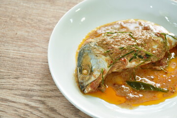 spicy boiled mackerel topping chop lemon grass in red curry sauce on plate