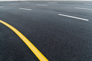 Asphalt road with white stripes and yellow lines