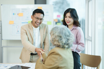 Asian entrepreneurs handshakes to congratulate the agreement between the two companies to enhance investment and financial strength. deal concept