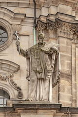 Obraz premium Old roof statute of priest or monk holding a big cross at Dome base of the Cathedral of Holy Trinity, historical center of Dresden, Germany.