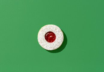 Christmas cookie isolated on a green background. Homemade linzer cookie.