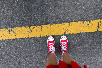 Top view of woman feet behind yellow line