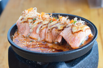 Grilled Salmon sushi with cream salad and spicy sauce placed on a Japanese grill, sushi is a traditional and popular food for Japanese people.