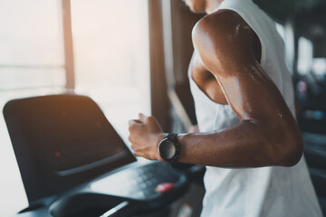 Asian athlete sportsman runner tan skin running on treadmill in fitness club. Cardio workout....