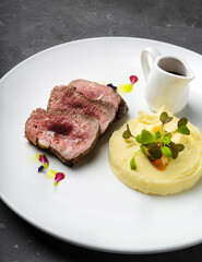 Meat with cherry sauce. Potato side dish.