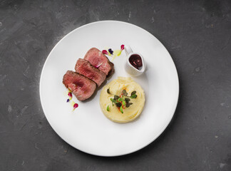 Meat with cherry sauce. Potato side dish.