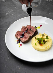 Meat with cherry sauce. Potato side dish.