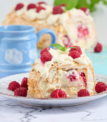 Baked meringue roll with cream and fresh red raspberry, white background.