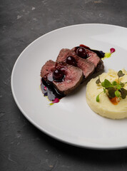 Meat with cherry sauce. Potato side dish.