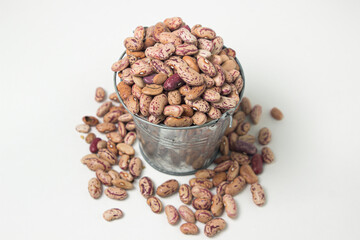 Small steel bucket with beans on a white background. Dried beans
