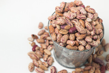 Small steel bucket with beans on a white background. Dried beans