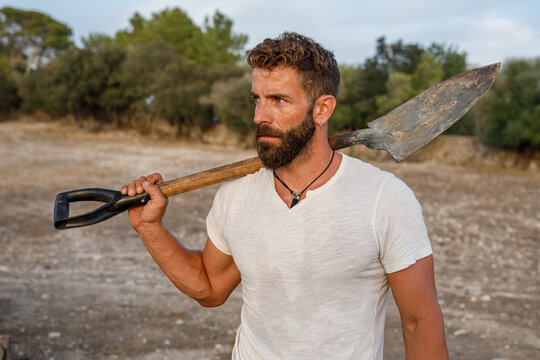 Bearded male farmer with shovel
