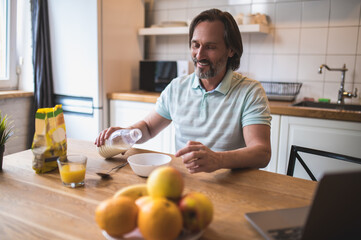 Fototapeta na wymiar Single man having breakfast in the kitchen at home