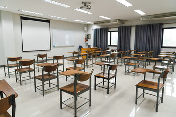 School classroom with many wooden chairs well-arranged in rows with no student