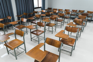 School classroom with many wooden chairs well-arranged in rows with no student