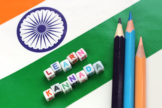 The inscription Learn Kannada on the background of the Indian flag and crayons.