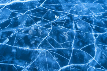 Ice on a frozen river. Background texture of blue ice with cracks in the snow. drone view.