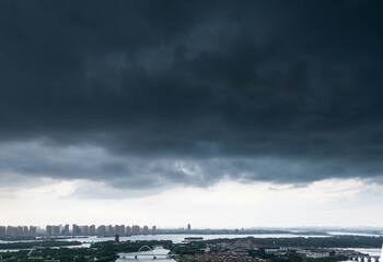Fototapeta premium Dark clouds over a city by the sea