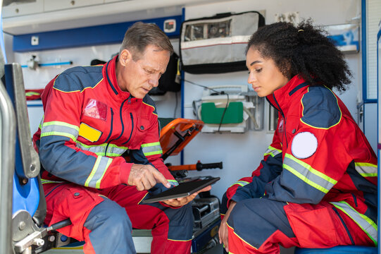 Two paramedics sitting in the ambulance car