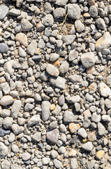 Abstract background with crushed gravel and small little grey rocks and stones, close-up view from directly above