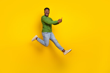 Fototapeta na wymiar Full length body size view of handsome trendy guy using device jumping fooling isolated on vivid yellow color background
