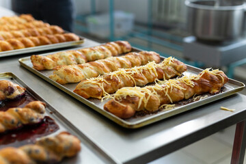 Cropped image of an appetizing dusted pie baked on the tray, they are baked on metal table.