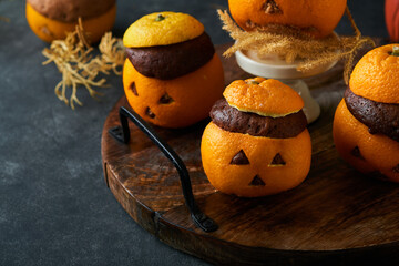 Halloween party jack-o-lantern chocolate orange cakes against the background of the old forest,...