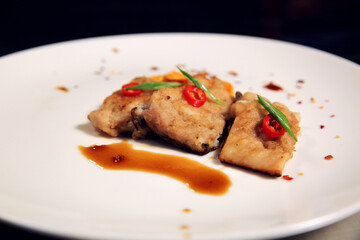 Pieces of meat on a white plate. Side view.