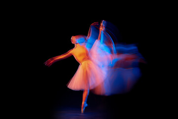 Dance of light and glow. Beautiful grace girl, female ballet dancer dancing isolated over black...