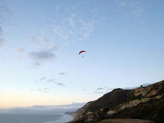 Parasailing over Pacific Ocean near coastal cliffs
