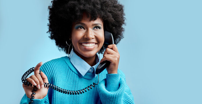 Telecom landline, phone or black woman talking, communication on blue mockup studio background. Happy, smile or young African girl model speaking to contact on vintage phone with mock up space
