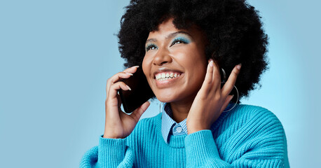 Black woman, talking on smartphone and smiling on blue background in studio mockup. Stylish african american lady with fashion afro, cellphone conversation and happy talk on 5g communication network