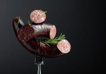 Spanish black pudding or blood sausage with rosemary on a fork.